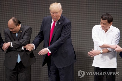 '어떻게 하는 거지?' 트럼프 APEC 정상 단체 악수사진 논란
